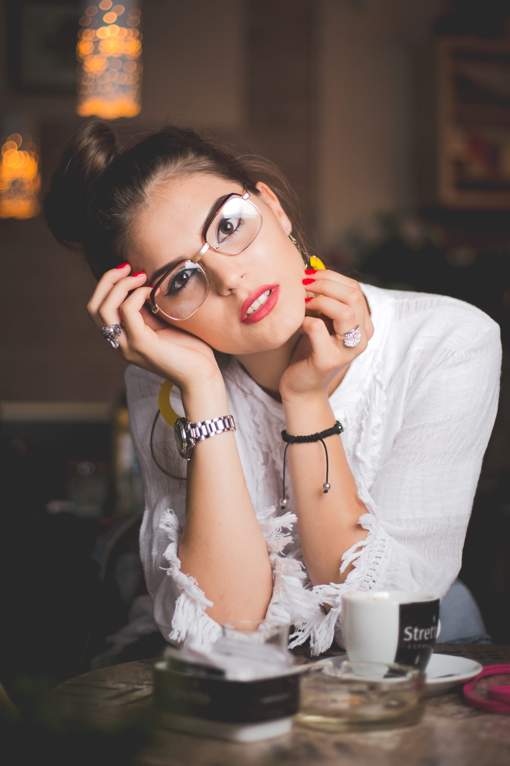 Woman wearing clear frames drinking coffee