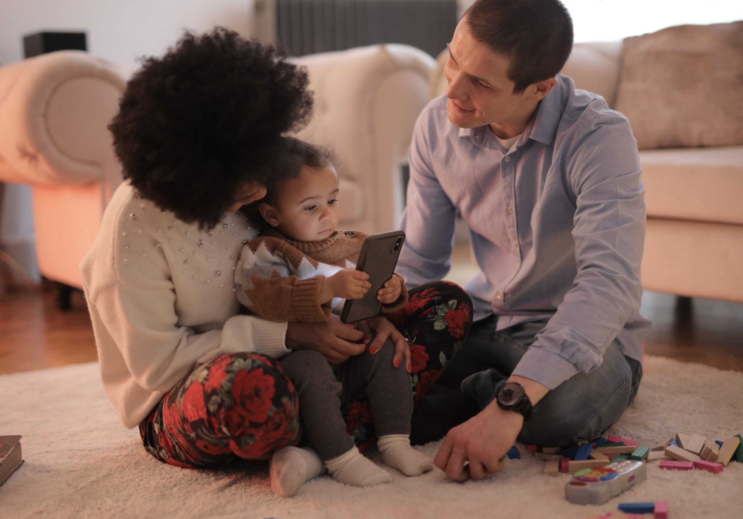 Parents and child playing on smartphone