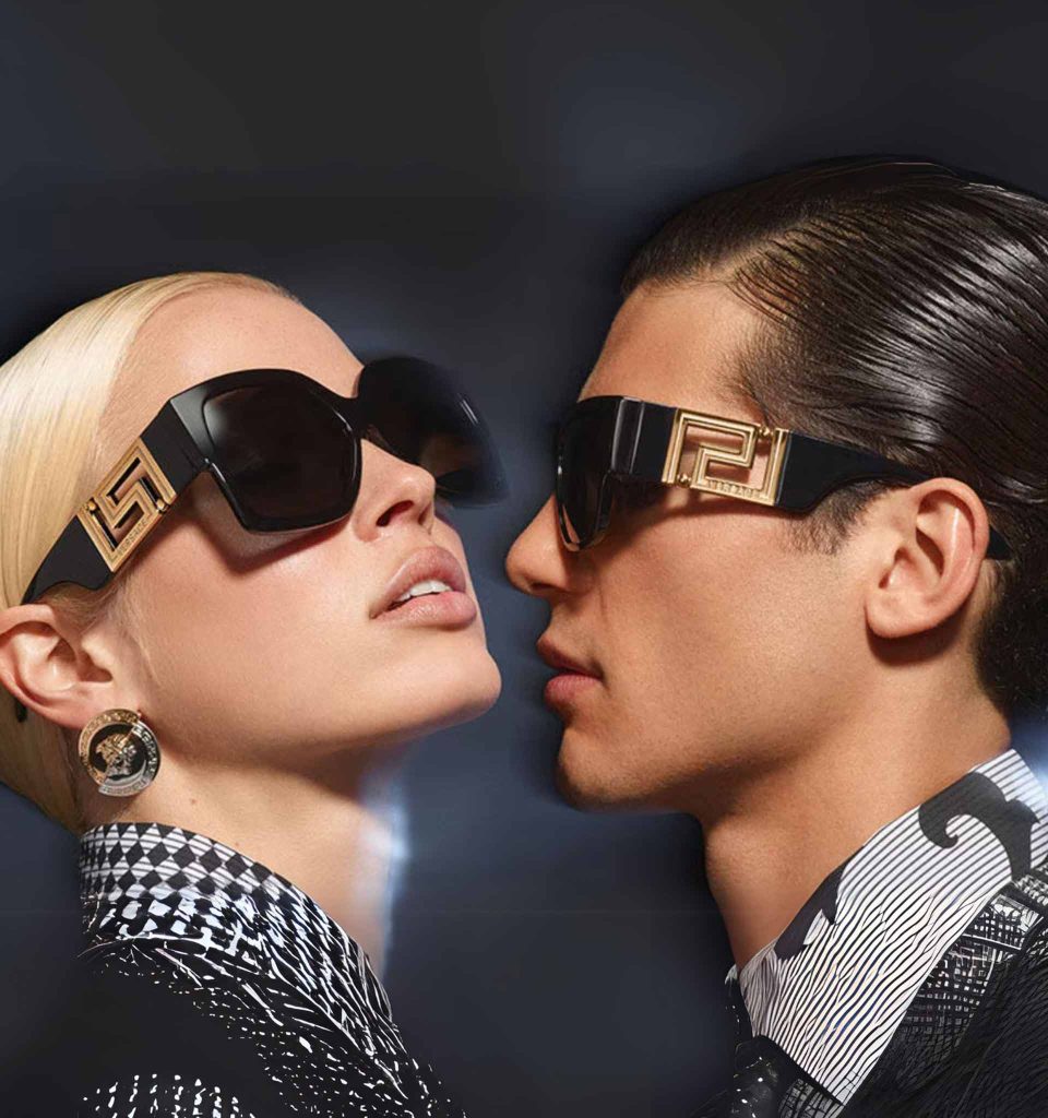 A brown-haired man and a blonde woman wearing Versace sunglasses featuring thick black frames and a bold gold logo