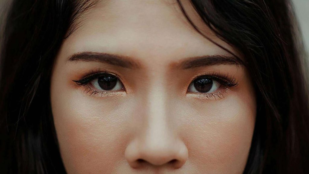 A woman with dark hair and dark brown eyes