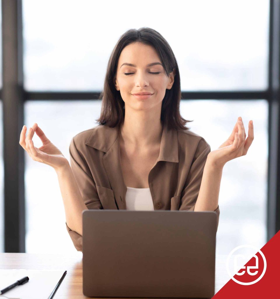 A woman meditating at her desk, emphasizing stress management to help reduce eye pressure and support eye health