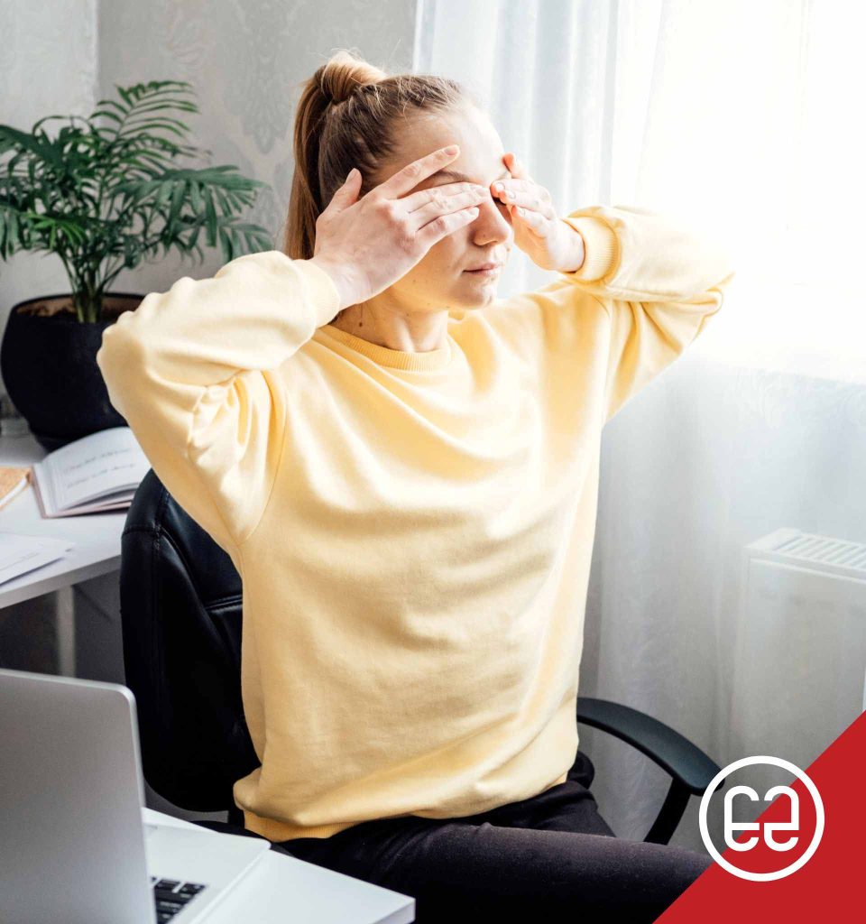 A woman practicing the palming eye exercise at her desk, showing a simple way to reduce eye strain and pressure