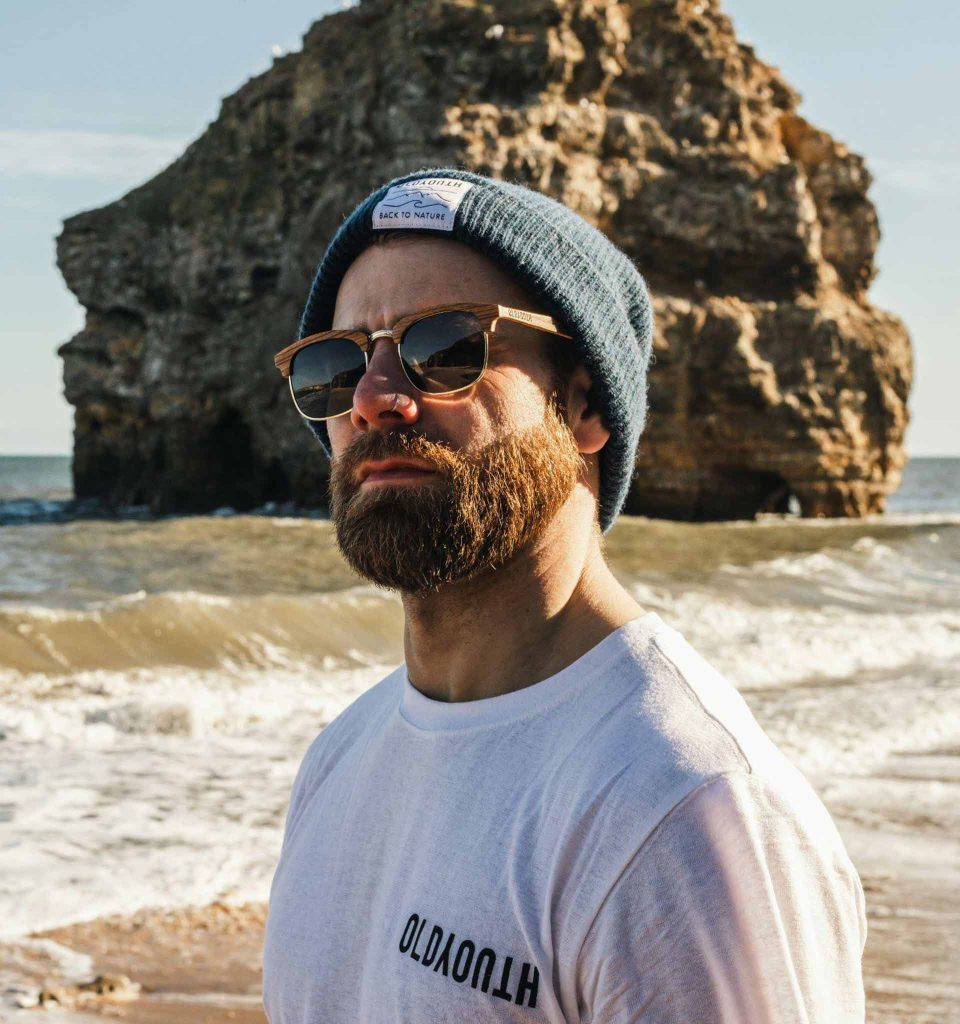 A man wearing white T-shirt and classic sunglasses featuring brown and gold frames