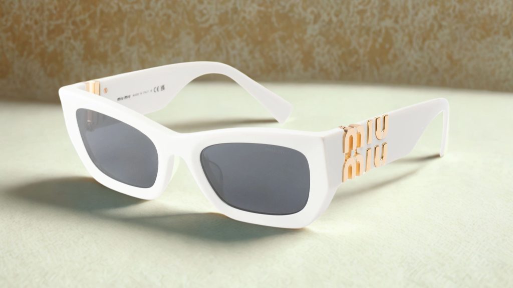 Sunglasses with chunky white frames, a gold Miu Miu logo on the arms, and rectangular dark grey polyamide lenses