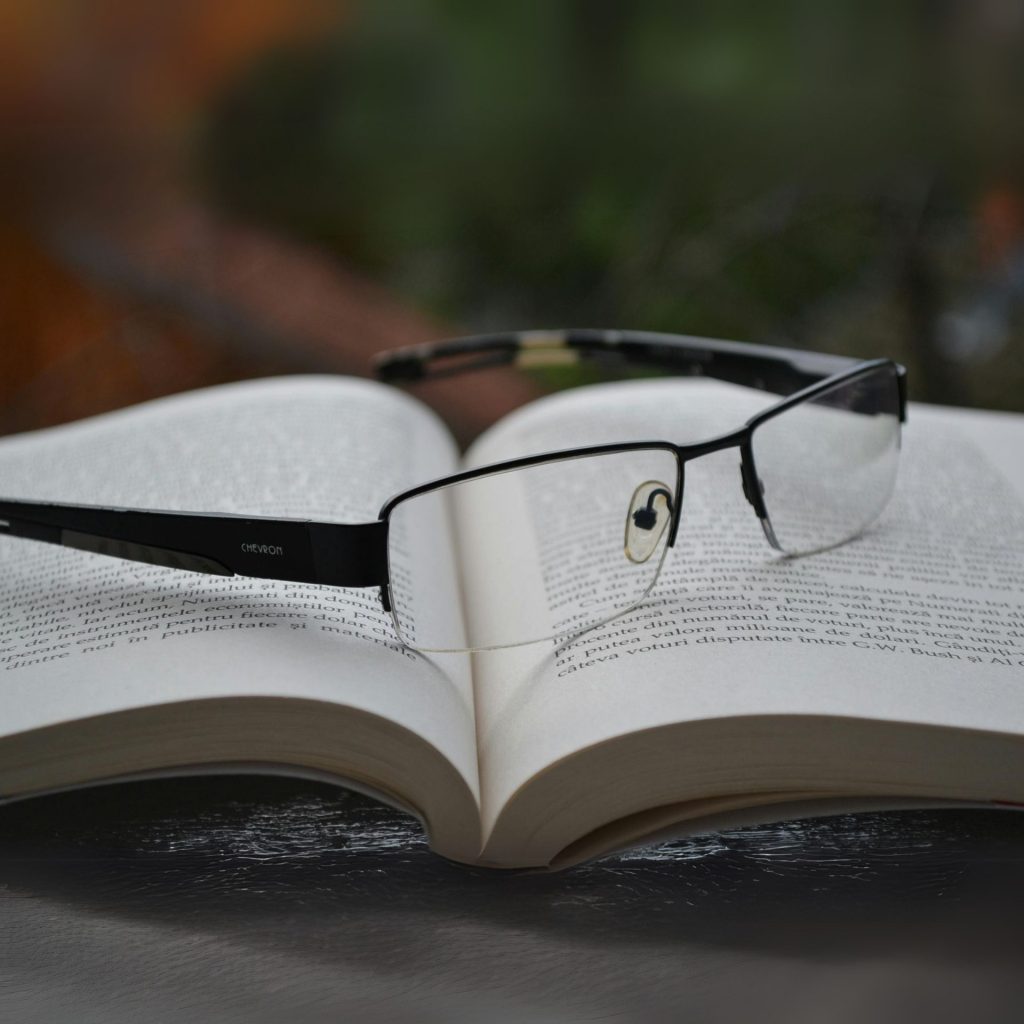 Bifocal reading glasses sit atop an open book