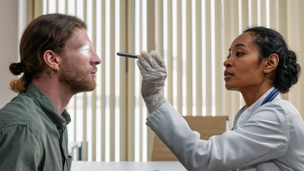 An eye doctor examines a man with conjunctivitis