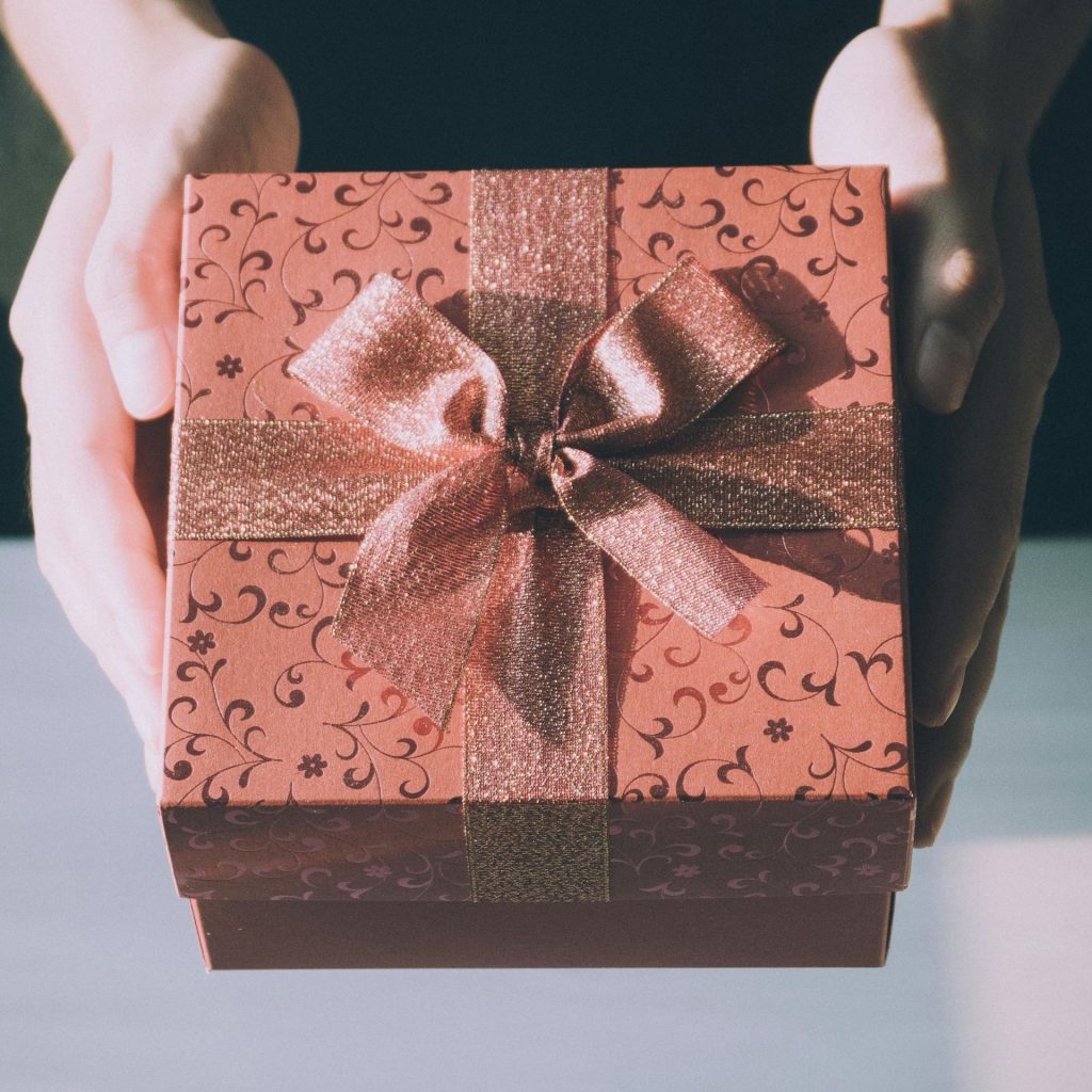 A person handing over a wrapped gift
