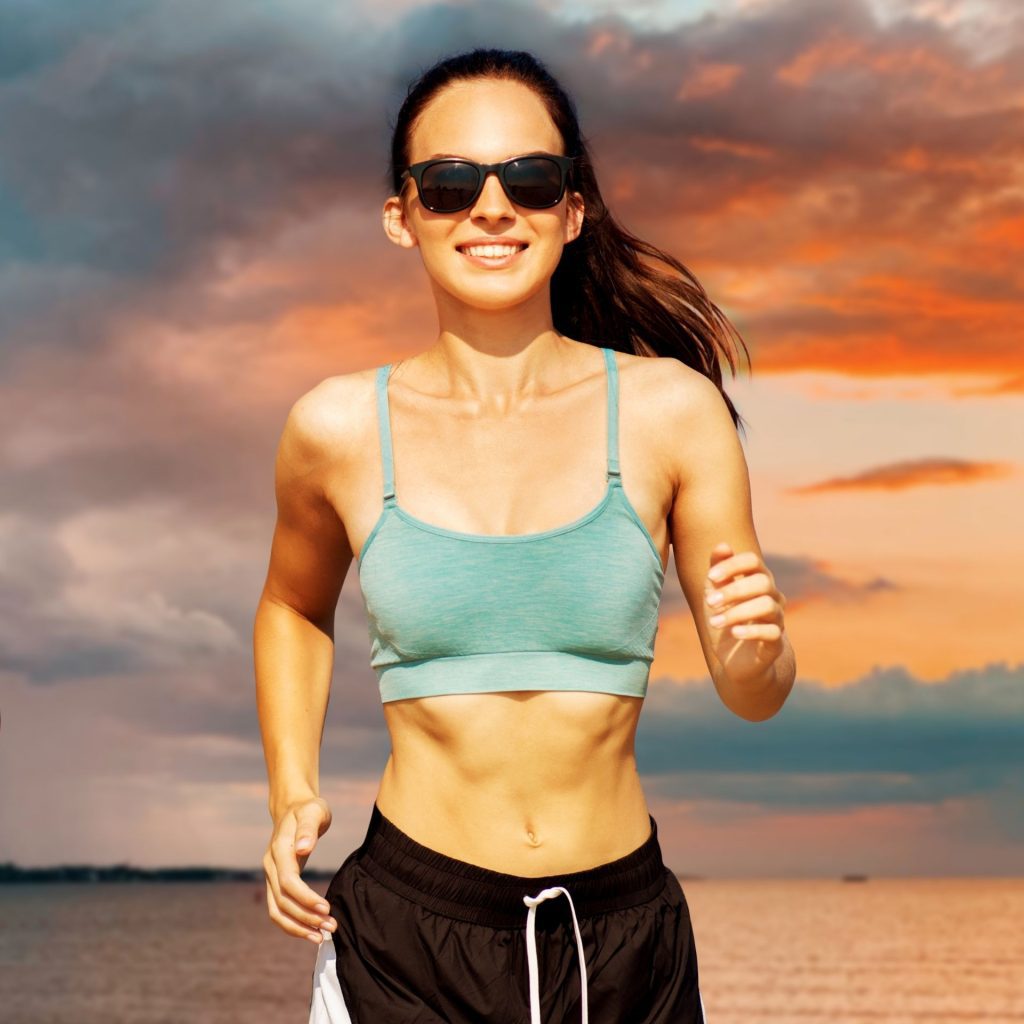 Athletic woman wearing sports clothes and running sunglasses