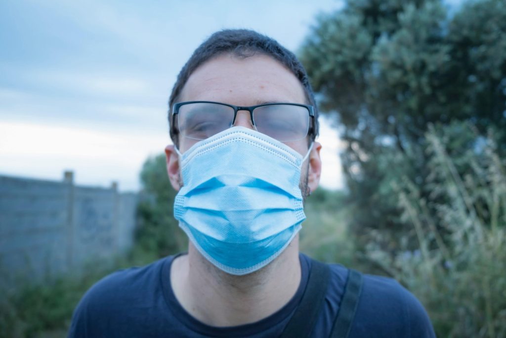 Close-up of a man in a face mask with fogged-up glasses