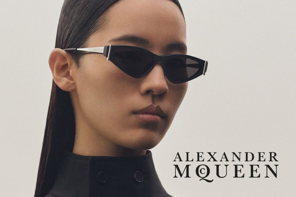 Model wearing Alexander McQueen sunglasses with black frames and tinted lenses