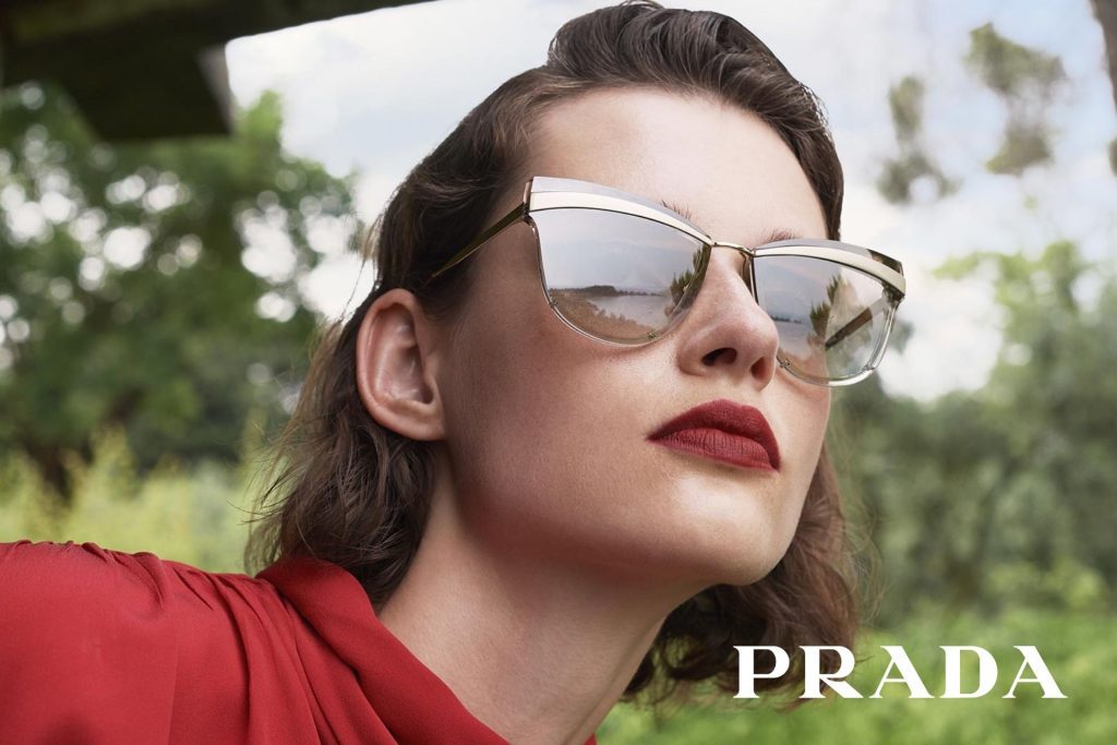 Model wearing Prada sunglasses featuring cat-eye frames and gold accents