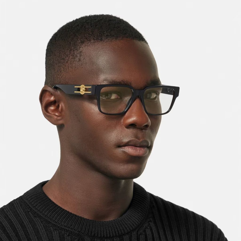 A man wearing thick, full-rim, square, black Versace prescription glasses