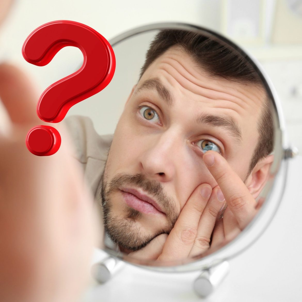 Man putting in a contact lens while looking in the mirror