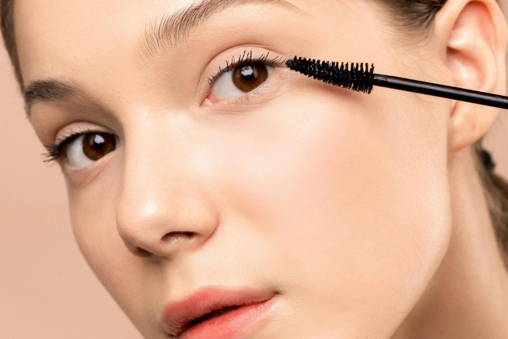 Woman applying mascara to her eyelashes
