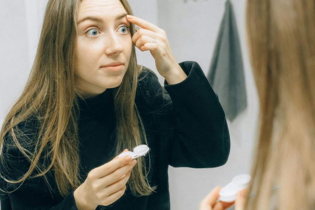 Woman removing contact lenses from her eyes