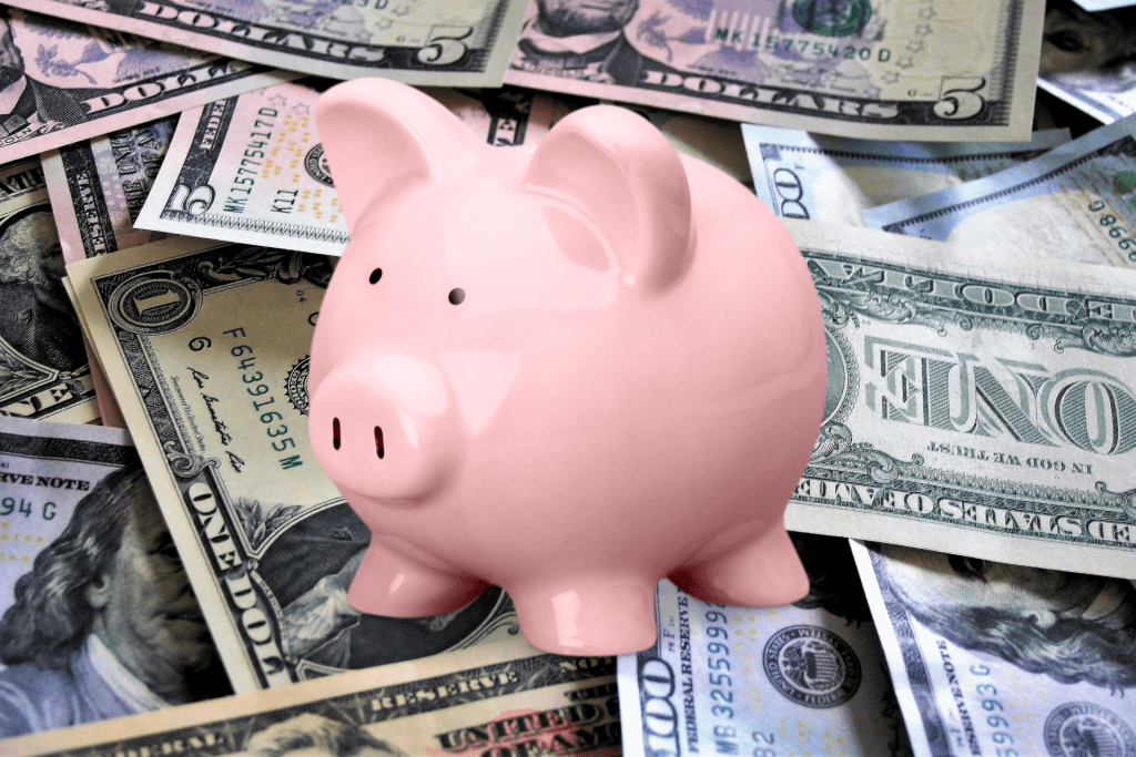 A piggy bank on top of a pile of cash