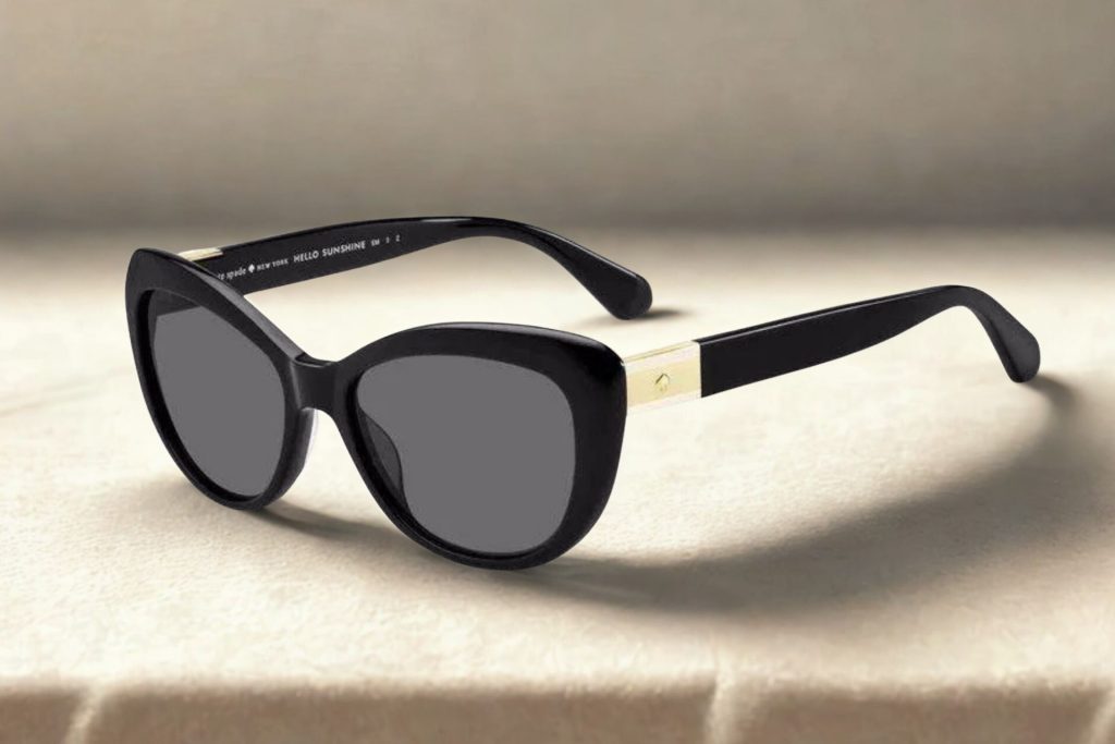 Black plastic cat’s eye frames with gray lenses and white gold metal stylings along the hinges