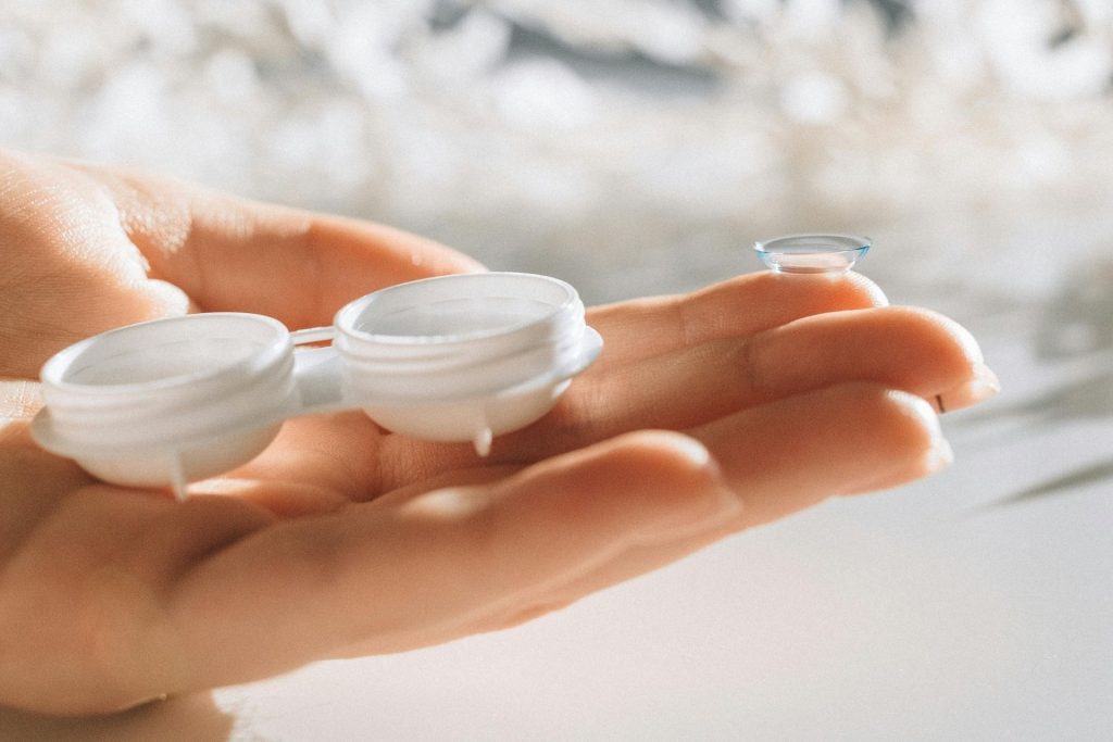 Contact lens and lens case sit on an open hand