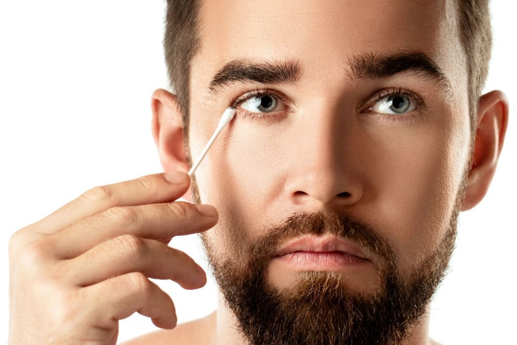 Man dabs his eye with a cotton swab