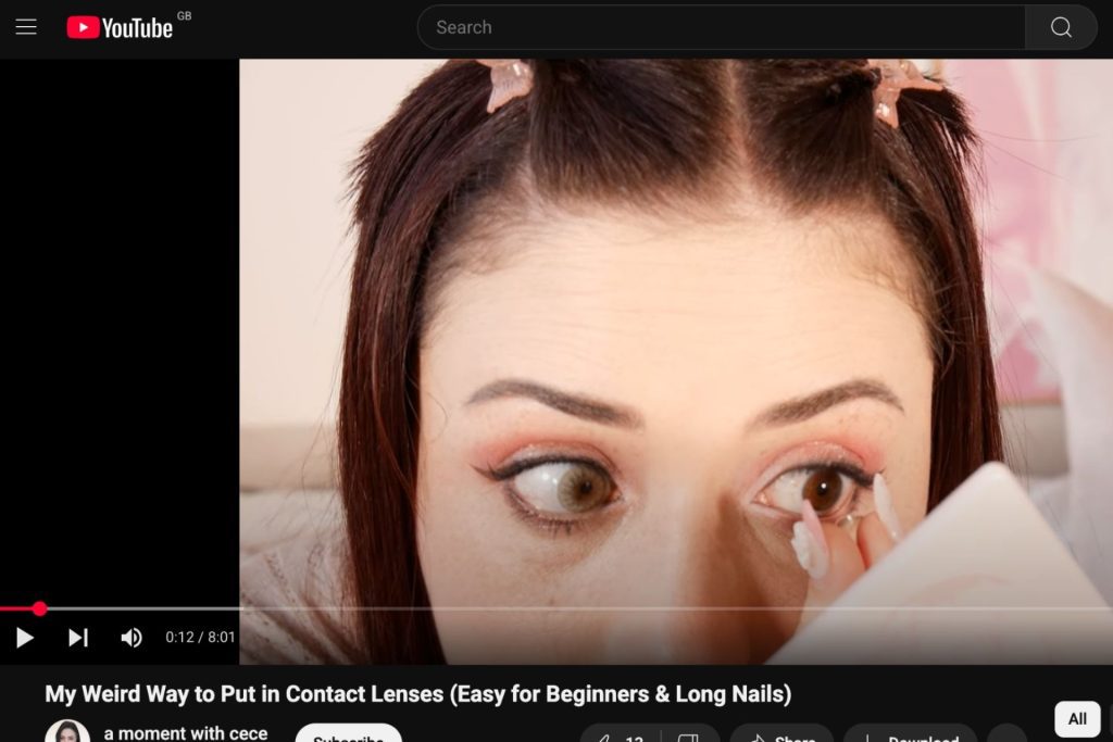 Woman putting in a contact lens using the pinching method