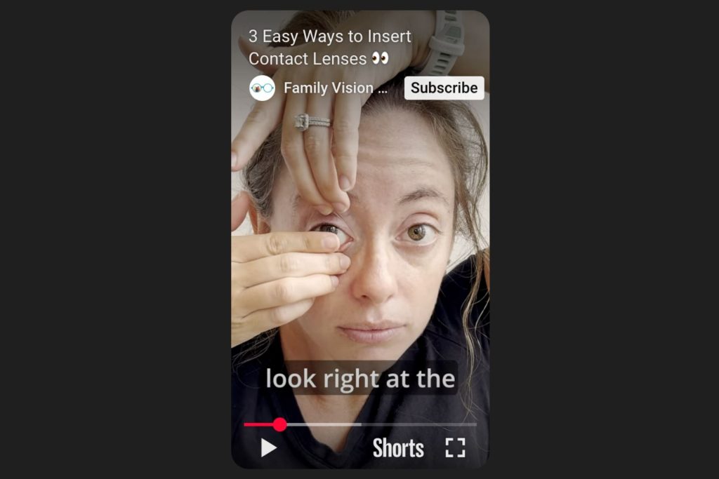 Woman putting in a contact lens using both hands
