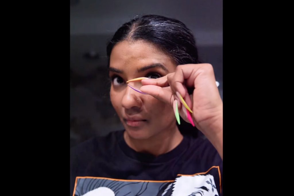 Kora Duke, an influencer with extra-long nails, removing her contacts using the pinch method