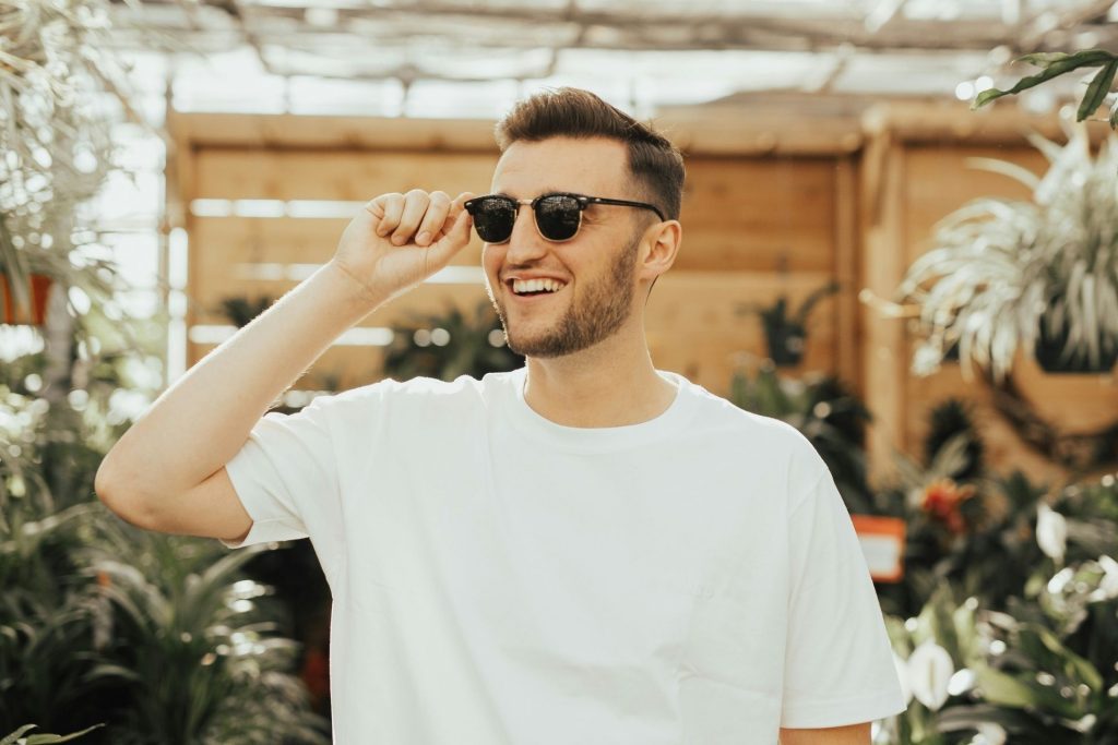 Man wearing a pair of designer sunglasses and a white T-shirt