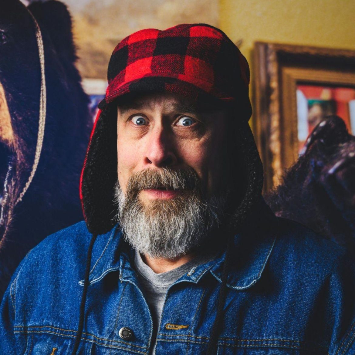 Surprised hunter with a bear by his shoulder