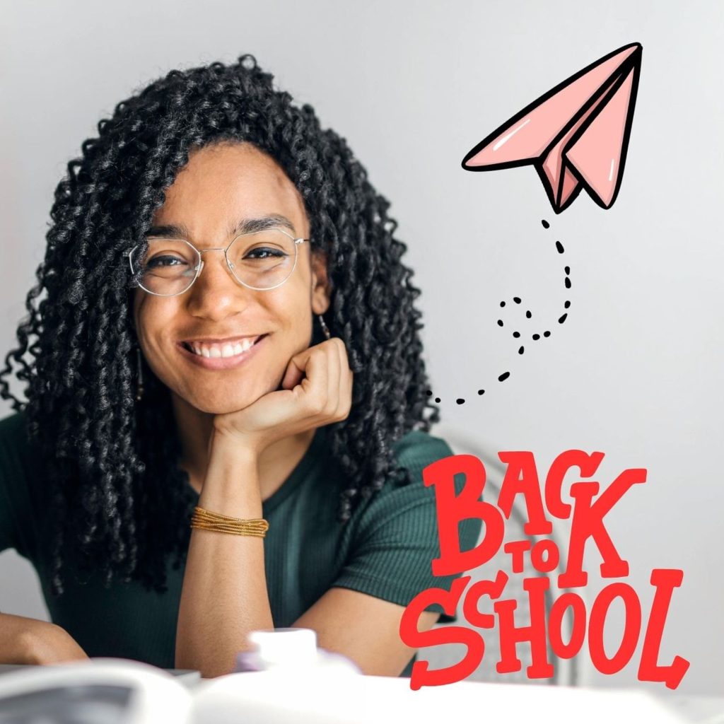Woman with glasses and a green shirt sits on a laptop