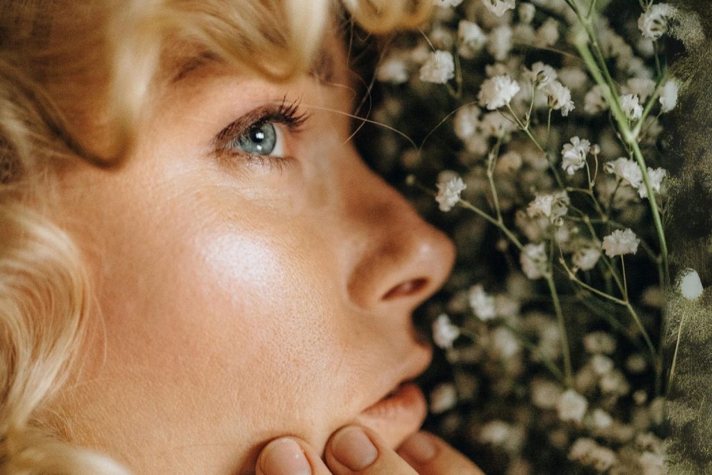 Close-up of a woman’s face next to white flowers