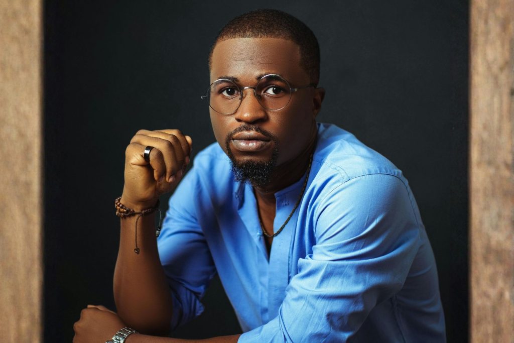 Man in blue dress shirt and rimless glasses