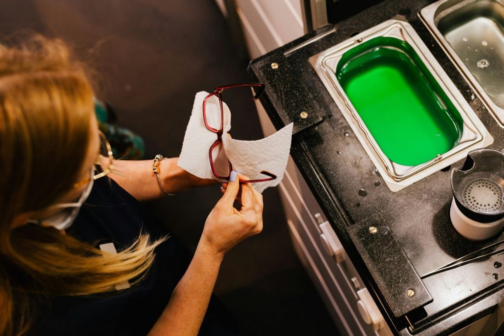 Woman cleans her glasses with a paper towel