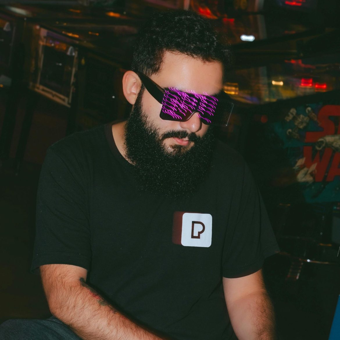 Man playing a video game with digital lights reflected on his glasses