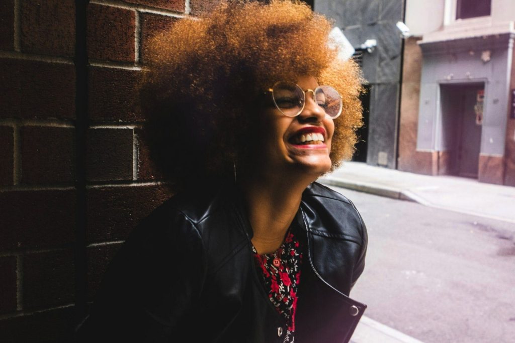Woman in leather jacket and round glasses