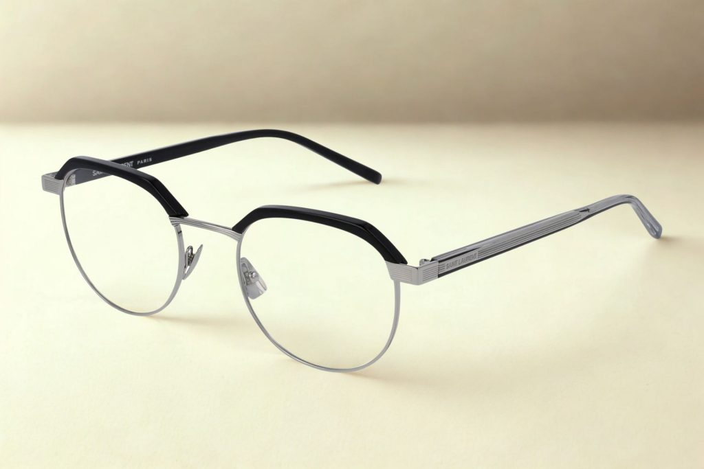 Full rim silver glasses with black upper rim/brows and the Saint Laurent logo along the hinges