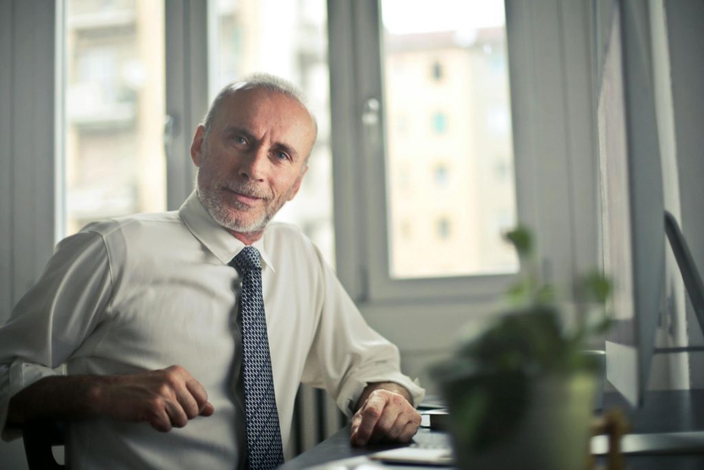 Smiling man sitting on a chair in front of a desk