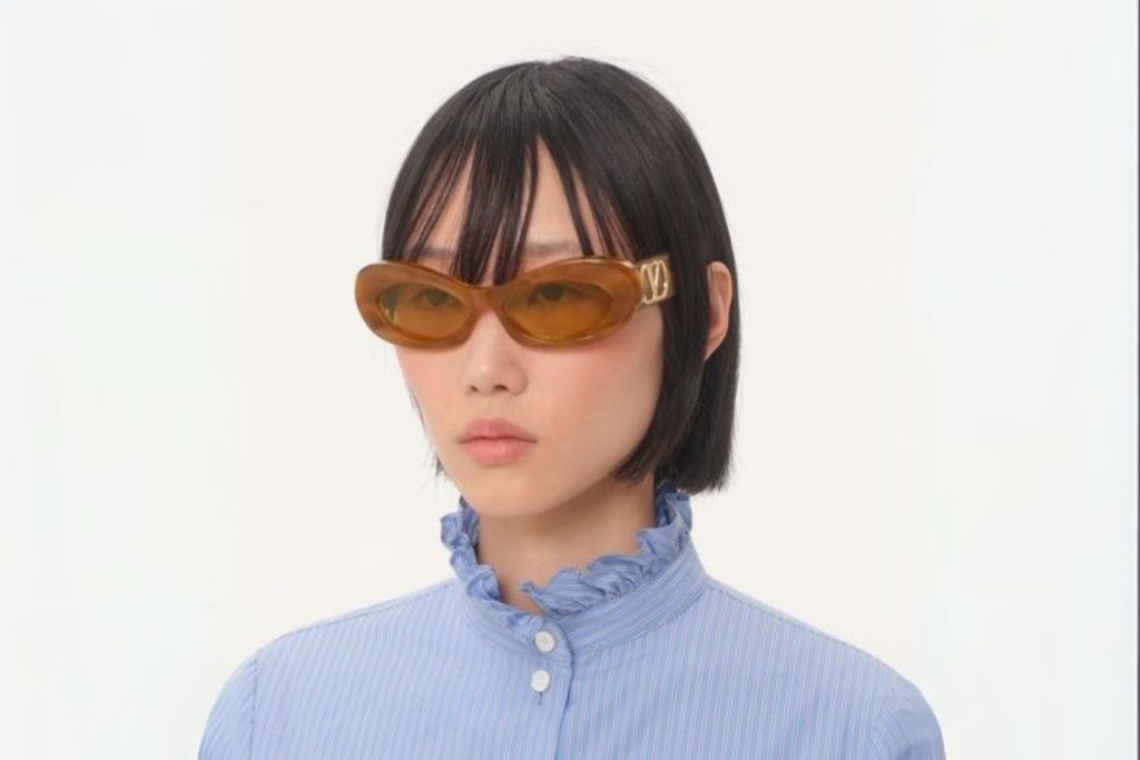 Model wearing Valentino sunglasses featuring oval acetate frames