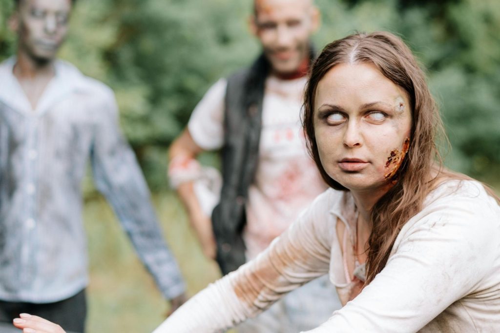 Female zombie attacking a car with two zombies behind her