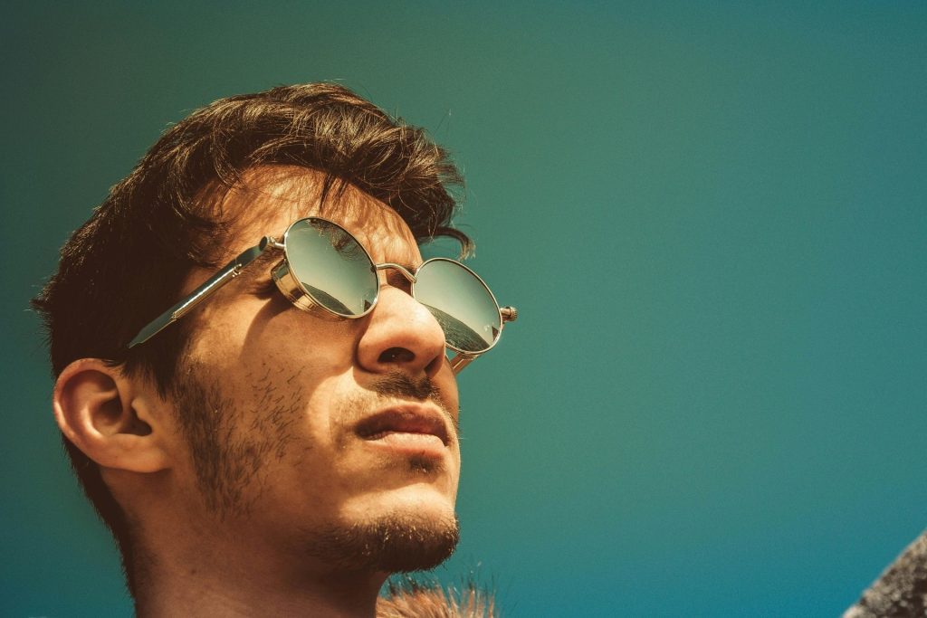 Man with sunglasses looks up