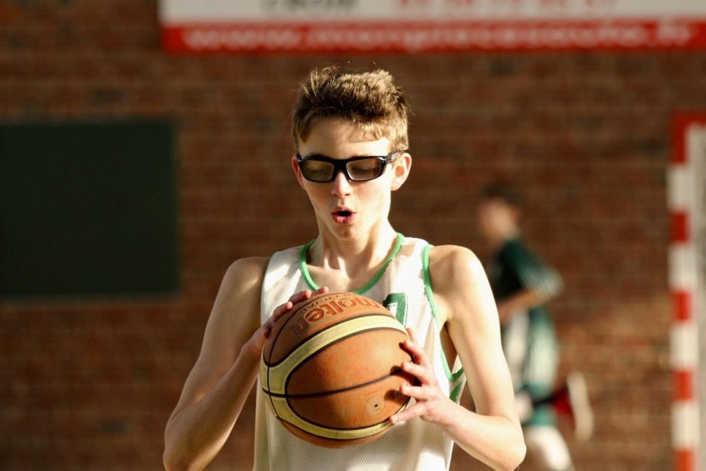 Teen wearing glasses prepares to shoot