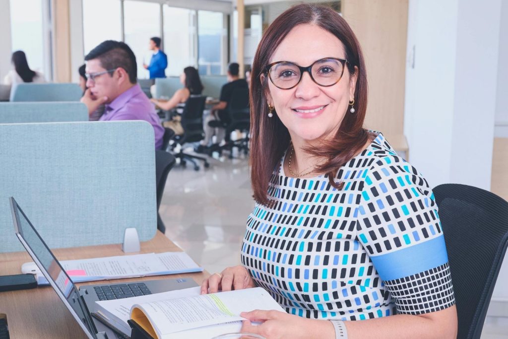 Office worker smiles while working in front of her computer