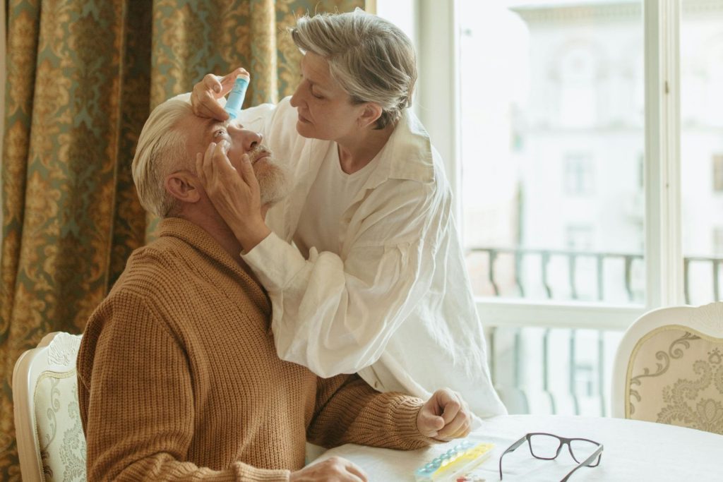 Woman helps a man with his eye drops