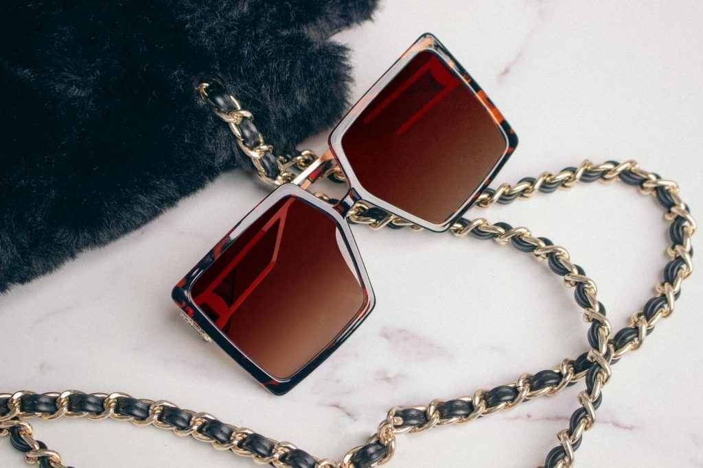Square sunglasses next to purse