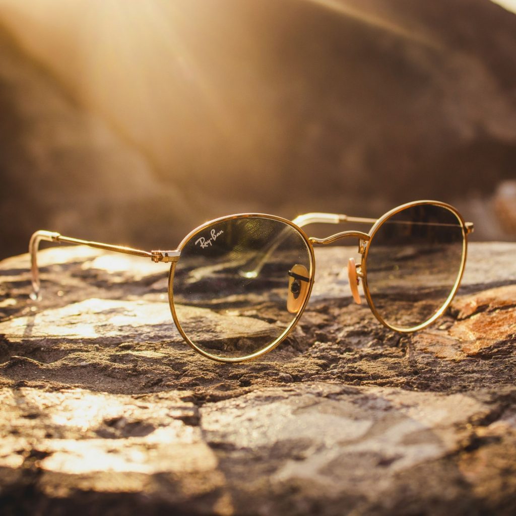 Golden Ray-Bans sitting on a rock