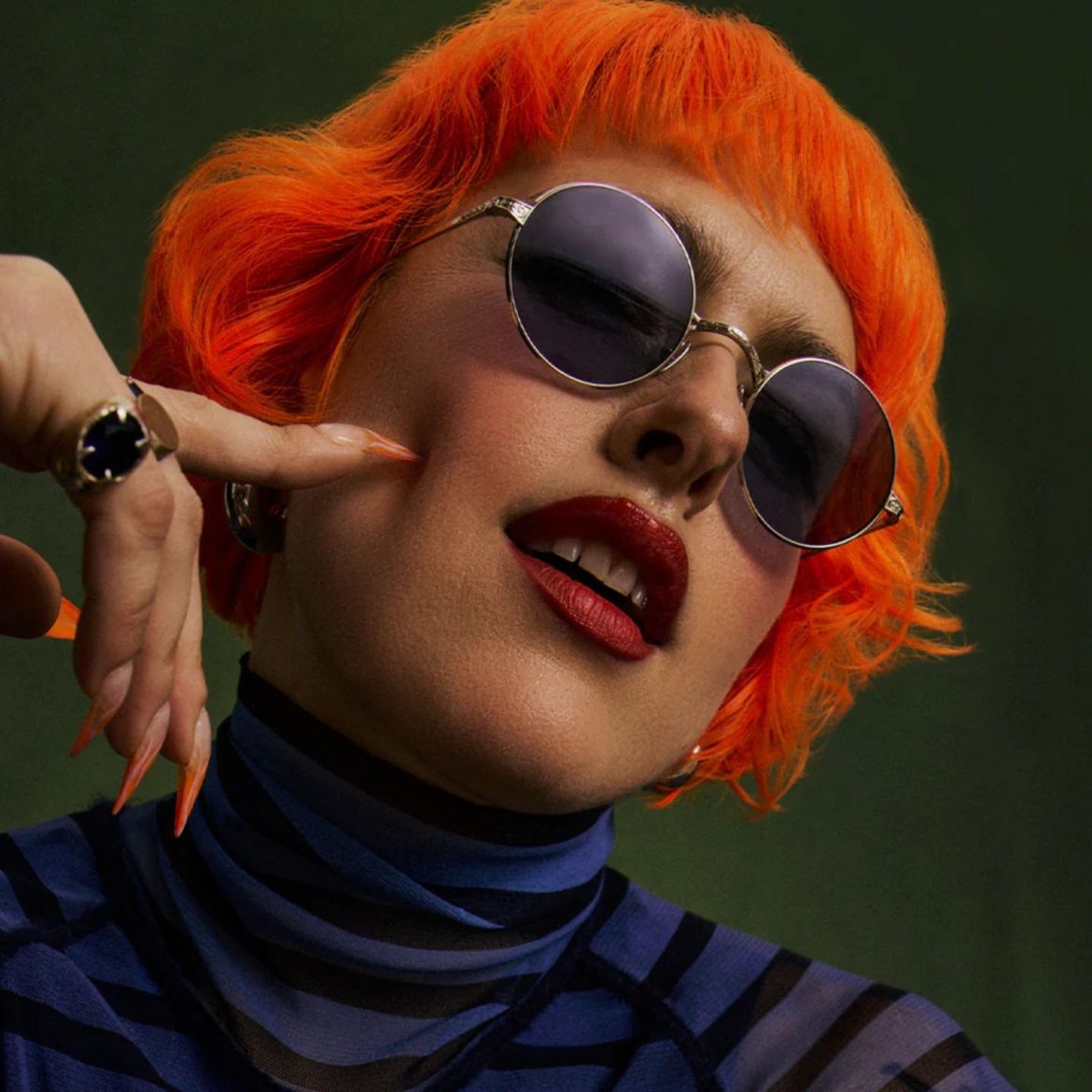 GLCO x Ozzy Osbourne Round Frames Woman with orange hair wearing GLCO x Ozzy Osbourne round fram