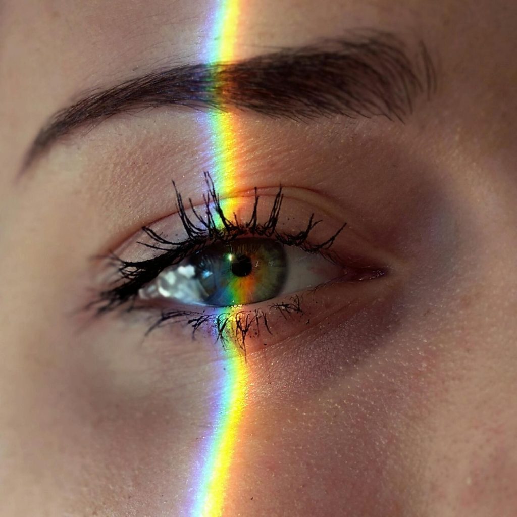 A vertical line of light reflects on a woman's eye.