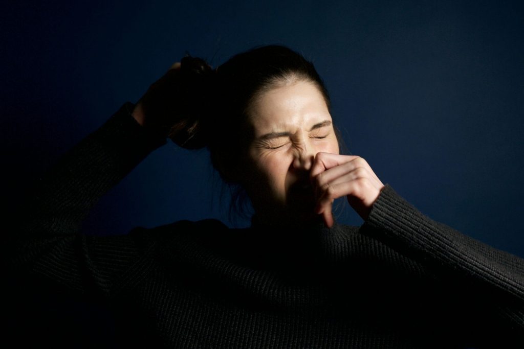 Woman closes her eyes and sneezes