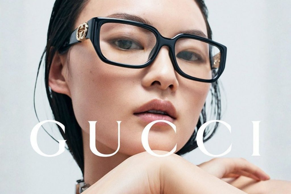 Model wearing Gucci square glasses featuring black frames