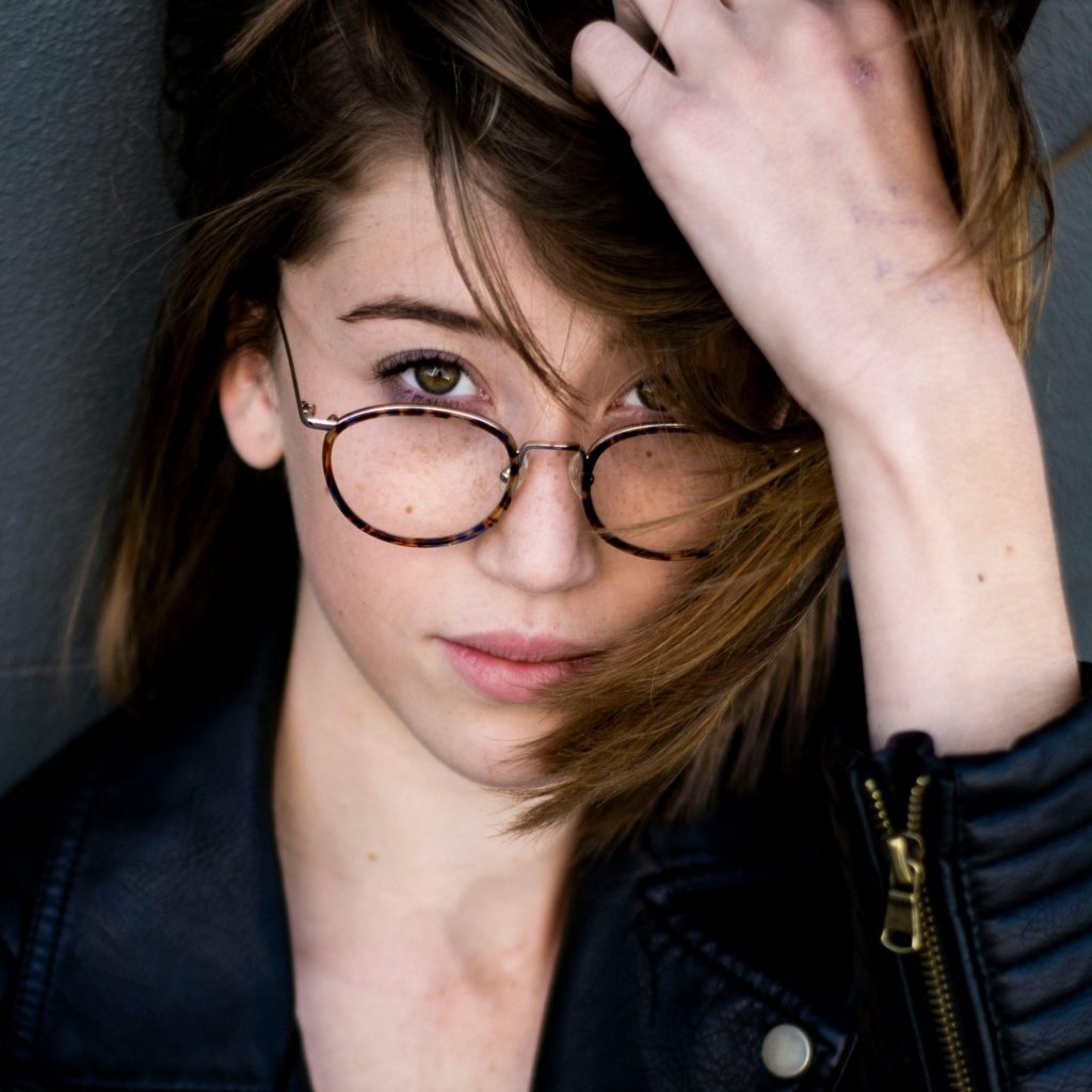 Woman with glasses runs her hand through her hair