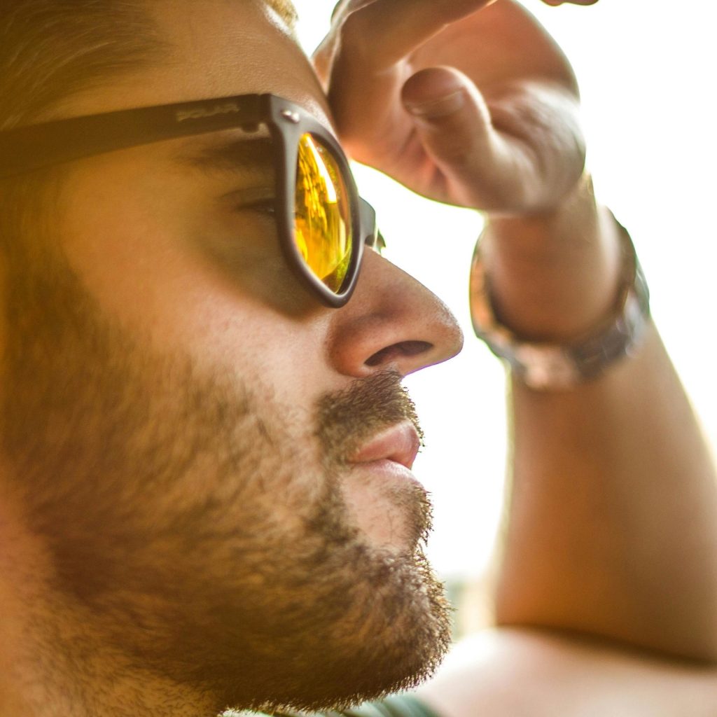 Man wearing sunglasses faces the sun